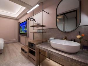 a bathroom with a large sink and a mirror at Mercure Suzhou Shilu Shantang in Suzhou +8 photos