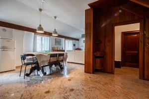 a kitchen and dining room with a table and refrigerator at San Mauro Prestige House - Burano Island in Venice