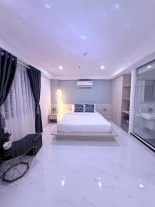 a bedroom with a large white bed and a sink at The Luxury Hotel in Ho Chi Minh City
