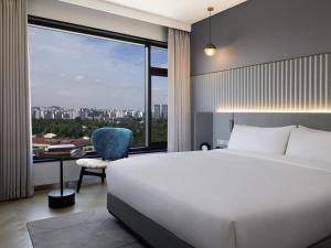 a bedroom with a bed and a desk and a window at Mondrian Seoul Itaewon in Seoul