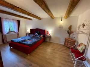 a bedroom with a red bed and a red chair at Zlatá Chalupa Heřmanovice in Heřmanovice