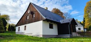 a white and black building with a gambrel roof at Zlatá Chalupa Heřmanovice in Heřmanovice