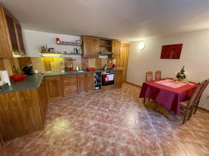 a kitchen with a table with a red table cloth at Zlatá Chalupa Heřmanovice in Heřmanovice +22 photos