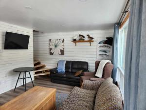 a living room with a couch and a tv at Chalet Lac Édouard cozy in La Tuque