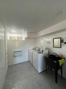 een kleine keuken met witte apparatuur en een wastafel bij Chalet Lac Édouard cozy in La Tuque