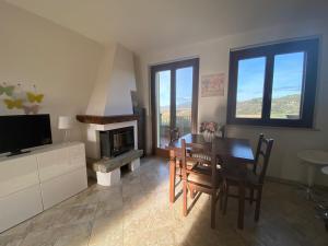 ein Esszimmer mit Tisch und Kamin in der Unterkunft Casa sulla collina in Corciano