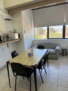a dining room with a table and chairs and a couch at Multiespacio Center in San Fernando del Valle de Catamarca