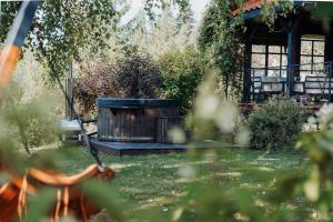 Gajówka في ايستينبا: حوض استحمام خشبي ساخن في حديقة مع شرفة مراقبة