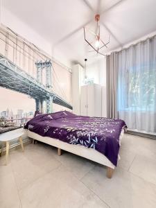 a bedroom with a purple bed and a bridge at Apartment near Central Park with garden view in Cluj-Napoca