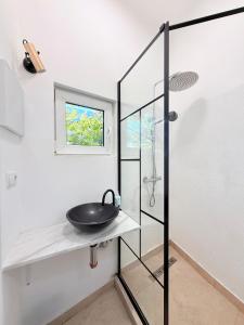 a bathroom with a sink and a glass shower at Apartment near Central Park with garden view in Cluj-Napoca +2 photos