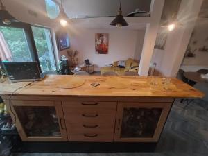 eine große Kücheninsel aus Holz im Wohnzimmer mit einem Laptop in der Unterkunft Casuta din Livada 2 