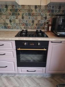 eine Küche mit einem schwarzen Herd mit Backofen in der Unterkunft Casuta din Livada 2 