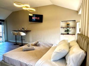 Un dormitorio con una cama y un televisor en la pared. en Suite Reale, en Massino Visconti