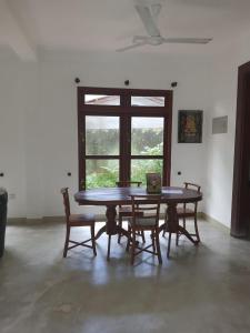 マータラにあるVilla5の窓のある部屋にあるテーブルと椅子