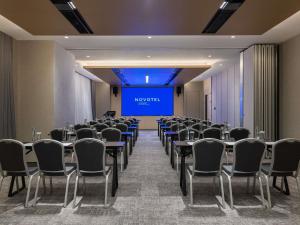 a conference room with tables and chairs and a projection screen at Novotel Shanghai Caohejing in Shanghai +93 photos