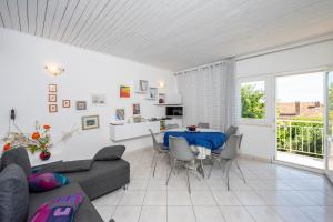 a living room with a blue table and chairs at Holiday House Lido in Orebić