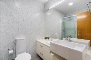 方The Sun and Sea Apartment by Minho's Guest的带水槽和马桶的白色浴室 更多16张照片