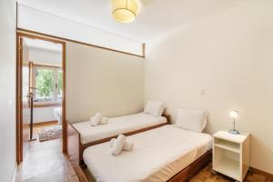 方The Sun and Sea Apartment by Minho's Guest的有两张床和一面镜子的卧室