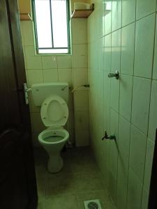 een kleine badkamer met een toilet en een raam bij Lakesong Haven BNB, Naivasha, Kenya in Naivasha