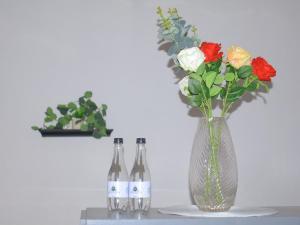 two bottles of wine and a vase with flowers at Mahlako Guest Lodge in Polokwane