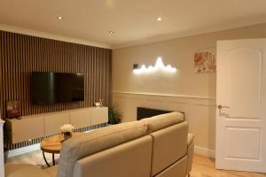ein Wohnzimmer mit Sofa und Fernseher in der Unterkunft Modern, Spacious Home Near Manchester - Perfect for Families group in Hollinwood + 32 Fotos
