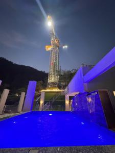 a building with a tower in the background with blue lights at The Nature's Nook - Best Stay in Shivpuri, Rishikesh, Hotel & Rooms in Shivpuri