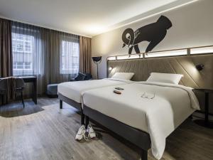 a hotel room with a large bed with a cat on the wall at ibis Styles Bielefeld City in Bielefeld +89 photos