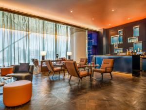 a lobby with chairs and tables and a bar at Fairmont Doha in Doha