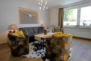 a living room with a couch and a table at Upland-Flair Ferienwohnung WALDPFAD im Zentrum! in Willingen