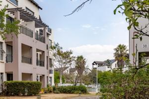 a row of white apartment buildings with trees at Be My Guest - The View Dainfern in Fourways