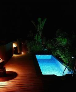 Una piscina de noche con terraza de madera. en Stylish beautiful and exotic Oleandro glass Suite, en Casares