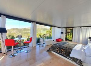 Un dormitorio con una cama grande y una ventana grande. en Stylish beautiful and exotic Oleandro glass Suite, en Casares