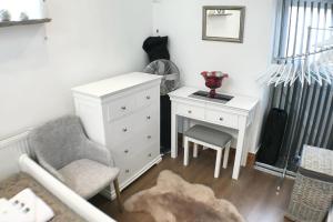 a bedroom with a white dresser and a chair and a desk at Charming 1 Bed Peak Dist Cottage Barn Alton Towers in Whiston