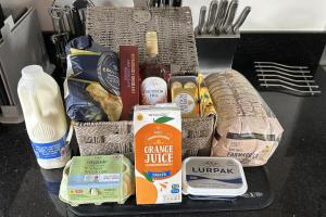 a basket of food and groceries on a table at Charming 1 Bed Peak Dist Cottage Barn Alton Towers in Whiston +17 photos