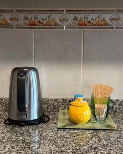 a toaster and a yellow vase on a counter at MJ Guest House in Póvoa de Varzim