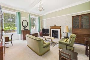 a living room with green furniture and a fireplace at Host & Stay - Thorneville House in Knaresborough