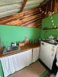 a kitchen with a sink and a refrigerator at Forest Retreat House Hammock & Private Terrace in Ban Nok