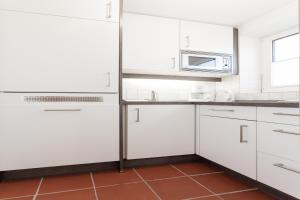 a kitchen with white cabinets and a microwave at Schönster Blick in Juist