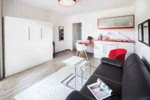 a living room with a couch and a kitchen at Appartementhaus Bracht - Kleine Welle in Juist