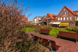 a park with benches and buildings and a train at Appartementhaus Bracht - Kleine Welle in Juist
