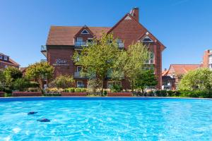 a large swimming pool in front of a building at Appartementhaus Bracht - Kleine Welle in Juist