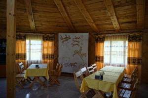 two tables and chairs in a room with windows at My Mongolia Eco Ger Camp in Nalayh