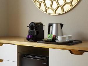a coffee maker and cups on top of a microwave at Mercure Tashkent South in Tashkent