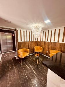 hol z żółtymi krzesłami i żyrandolem w obiekcie Flat Luxo Padrão w mieście Campina Grande +6 zdjęć