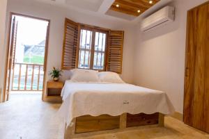 een slaapkamer met een bed en een groot raam bij Blue House Castillo View Private Jacuzzi & Colonial Balconies in Cartagena