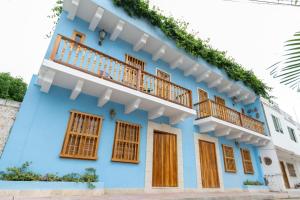 een blauw huis met houten ramen en een balkon bij Blue House Castillo View Private Jacuzzi & Colonial Balconies in Cartagena