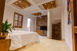 een grote slaapkamer met een bed en een televisie bij Blue House Castillo View Private Jacuzzi & Colonial Balconies in Cartagena