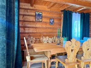 a dining room with a wooden table and chairs at Willa z widokiem na góry i jezioro - prywatny basen, sauna, balia in Międzybrodzie Bialskie +50 photos