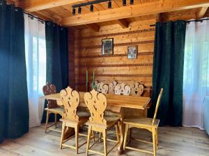 a dining room with a wooden table and chairs at Willa z widokiem na góry i jezioro - prywatny basen, sauna, balia in Międzybrodzie Bialskie
