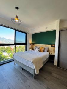 a bedroom with a large bed with a green wall at Original Studio ESCALANTE in San José